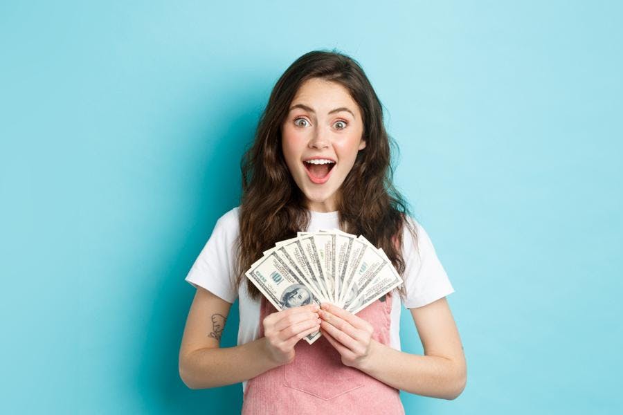 Lady holding $900 cash with happy surprised face